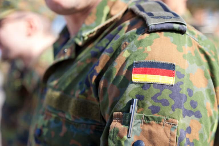 Bundeswehr-Soldat in Flecktarn-Uniform mit Deutschlandflagge – Soldaten und Strafbarkeit